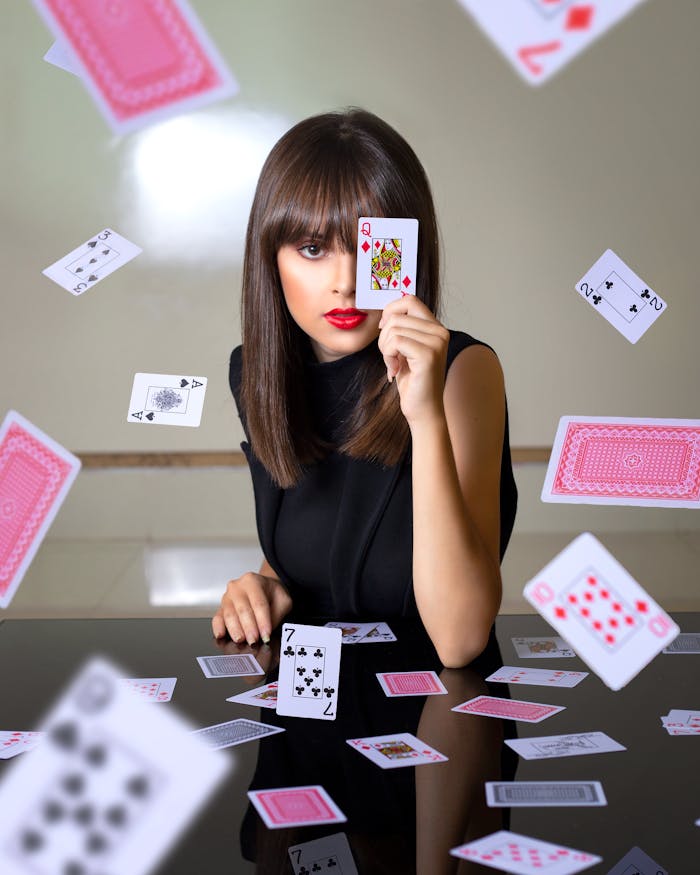 A brunette woman performs a captivating card trick in an indoor setting.